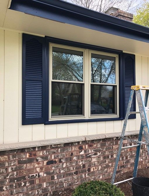 A shade of blue similar to Sherwin Williams In The Navy on window shutters.